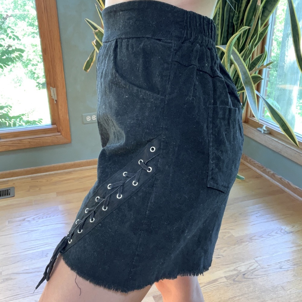 Black corduroy mini skirt with laces and silver details. One size fits all.